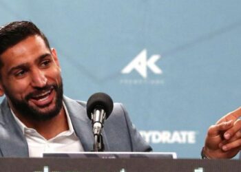 Amir Khan laughs and points his finger speaking at a news conference