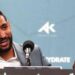 Amir Khan laughs and points his finger speaking at a news conference