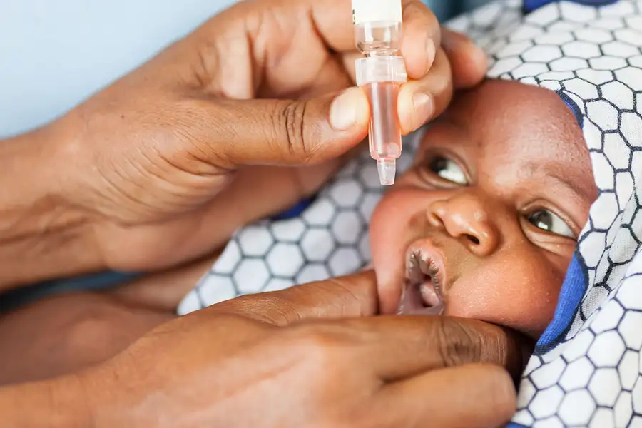Health worker administering vaccine in campaign for polio vaccination programs
