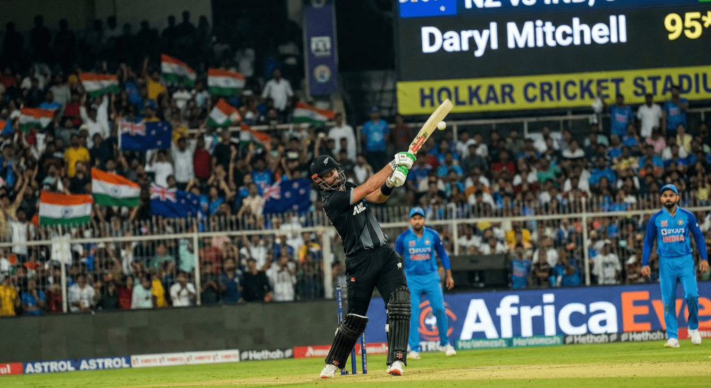 Action in Indore: Mitchell Powers Through New Zealand’s Daryl Mitchell plays a commanding shot during the high-stakes new zealand vs india 3rd ODI at the Holkar Cricket Stadium.