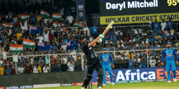 Action in Indore: Mitchell Powers Through New Zealand’s Daryl Mitchell plays a commanding shot during the high-stakes new zealand vs india 3rd ODI at the Holkar Cricket Stadium.